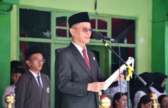 Syafitri Irwan membacakan sambutan Menteri Agama RI Nasaruddin Umar saat Upacara HAB ke-80 Kemenag di MAN 3 Palembang, menekankan pentingnya kerukunan umat dan kedaulatan AI.
