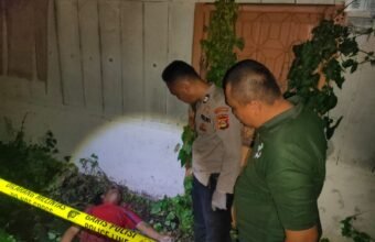 Petugas kepolisian saat melakukan olah tempat kejadian perkara (TKP) di pekarangan rumah kosong di Jalan Putri Rambut Selako, Kelurahan Bukit Lama, Kecamatan Ilir Barat I Palembang, lokasi ditemukannya seorang pria paruh baya dalam kondisi meninggal dunia, Minggu (4/1/2026) malam.