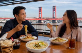 Sepasang kekasih sedang menikmati Mie Celor Palembang dengan kuah udang gurih yang kental, disajikan bersama udang segar, telur rebus, tauge, dan taburan bawang goreng, menjadi salah satu kuliner legendaris khas Sumatera Selatan yang menggugah selera. (Foto: Adit/Sriwijayaterkini.co)