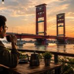 492 Peserta Ikuti Ujian Akademik Rikpsi Casis Diktukba TNI AD Gel II TA 2026 di Jasdam II/Swj Seorang pria ngopi di sore hari dengan view jembatan Ampera. (Foto: istimewa)