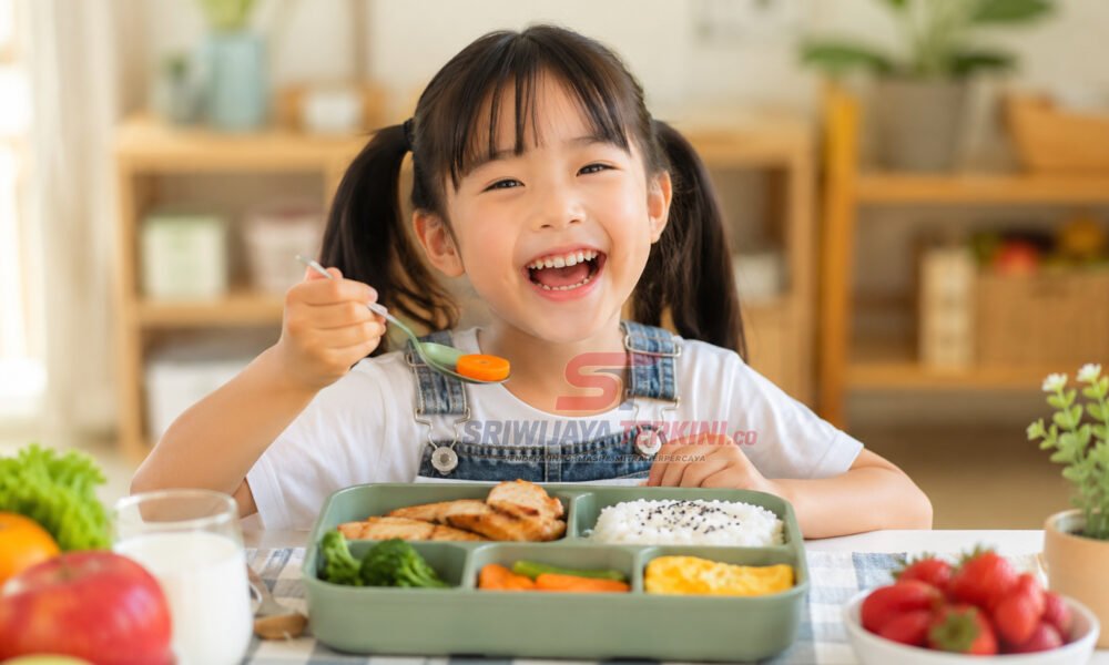 5 Menu Makan Siang Anak yang Bikin Semangat Beraktivitas Seharian, Nomor 3 Favorit Si Kecil! Seorang anak menikmati menu makan siang sehat berisi nasi, ayam, sayuran, telur, dan buah di meja makan dengan suasana ceria. (Foto: dok nara.sriwijayaterkini.id)